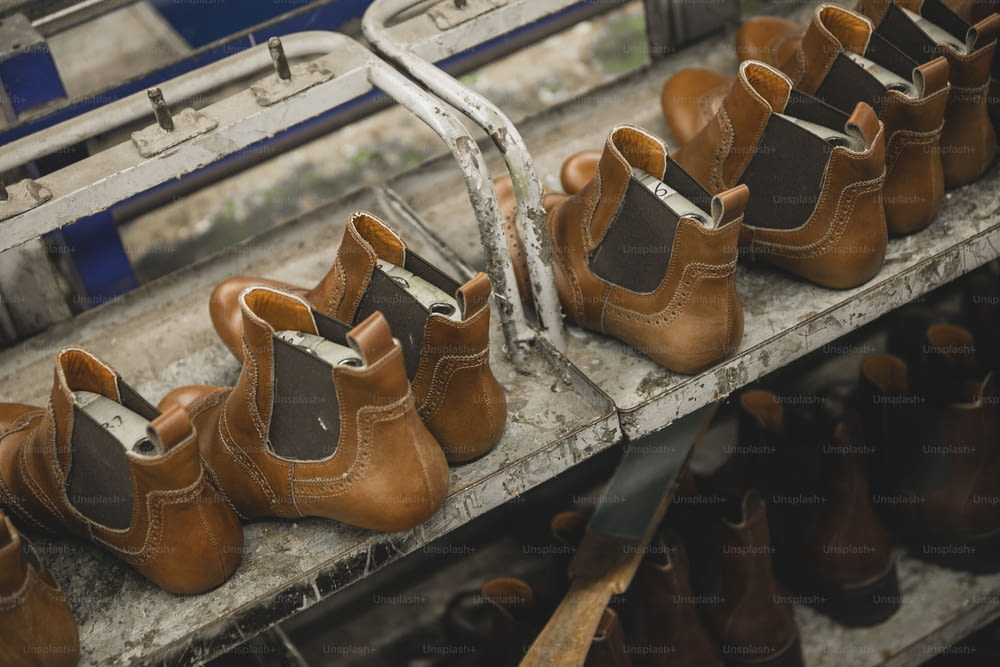 une rangée de chaussures brunes posées sur une étagère en métal