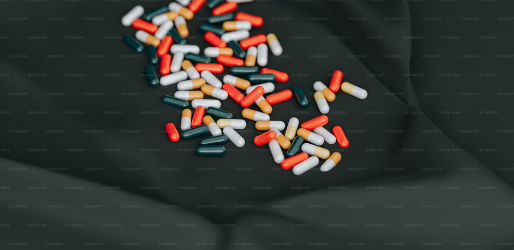 a pile of pills sitting on top of a black surface
