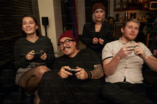 Un gruppo di persone sedute l'una accanto all'altra con in mano controller di gioco