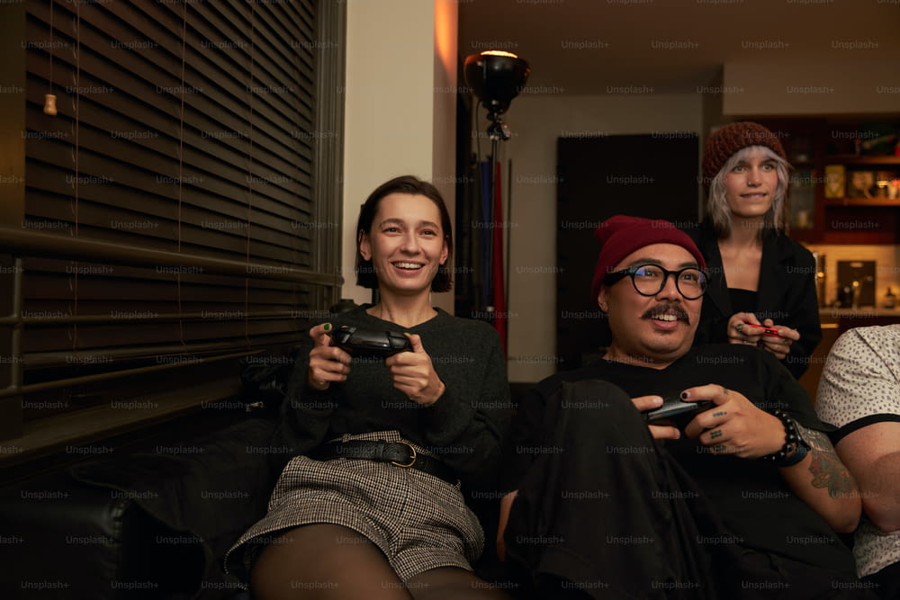 a group of people sitting next to each other holding game controllers