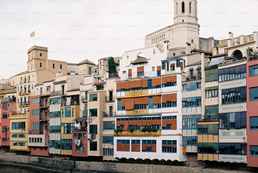 a row of multi - colored buildings next to a body of water