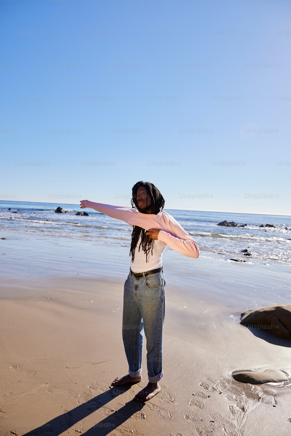 Una mujer parada en la cima de una playa de arena