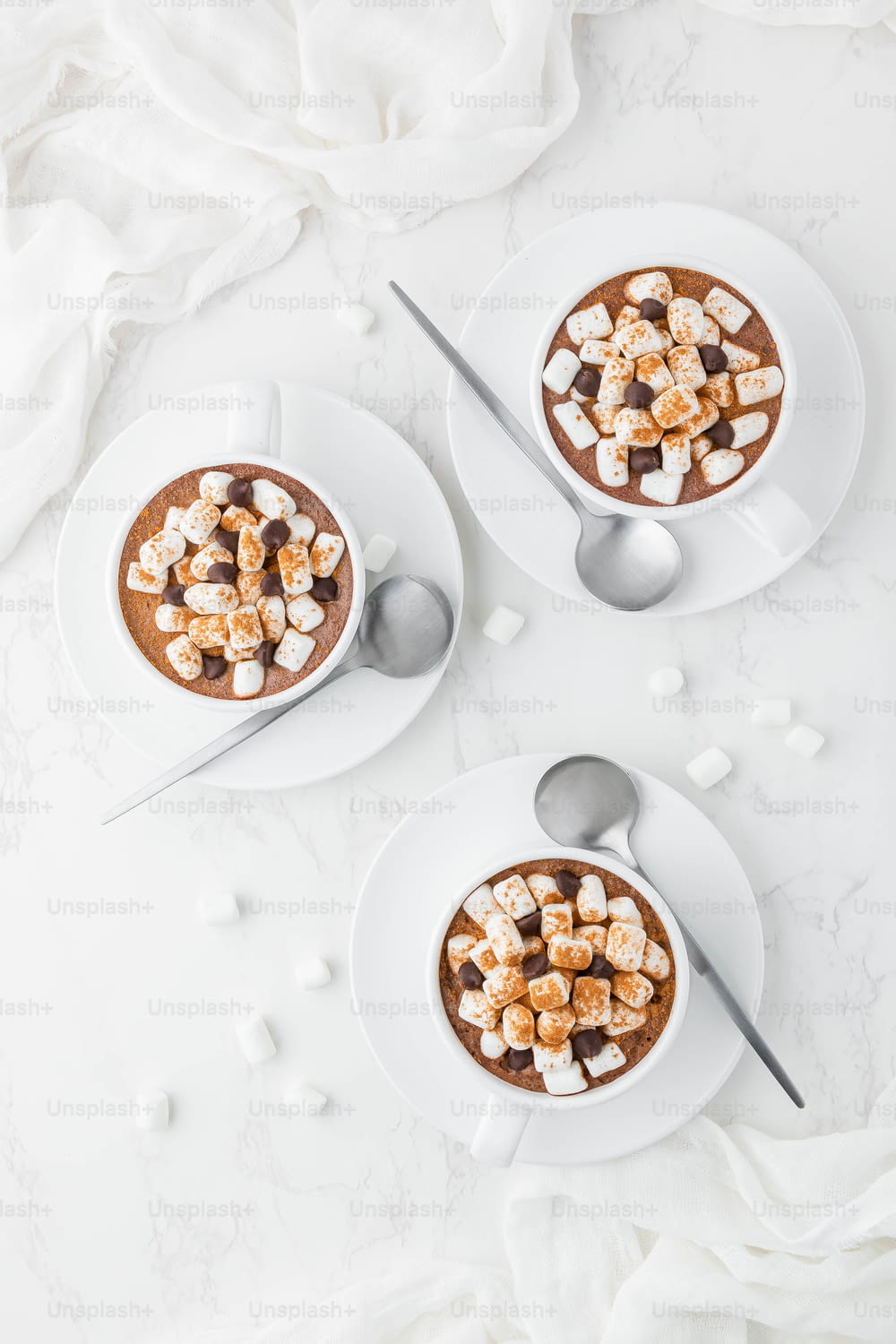 two bowls of hot chocolate topped with marshmallows