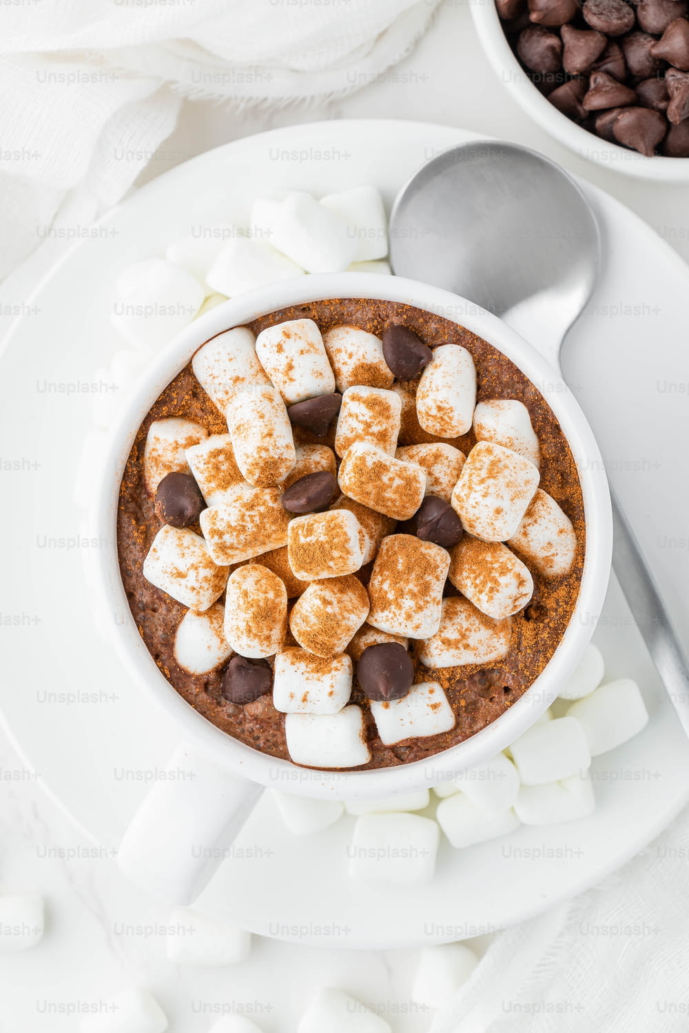 a bowl of hot chocolate and marshmallows on a plate