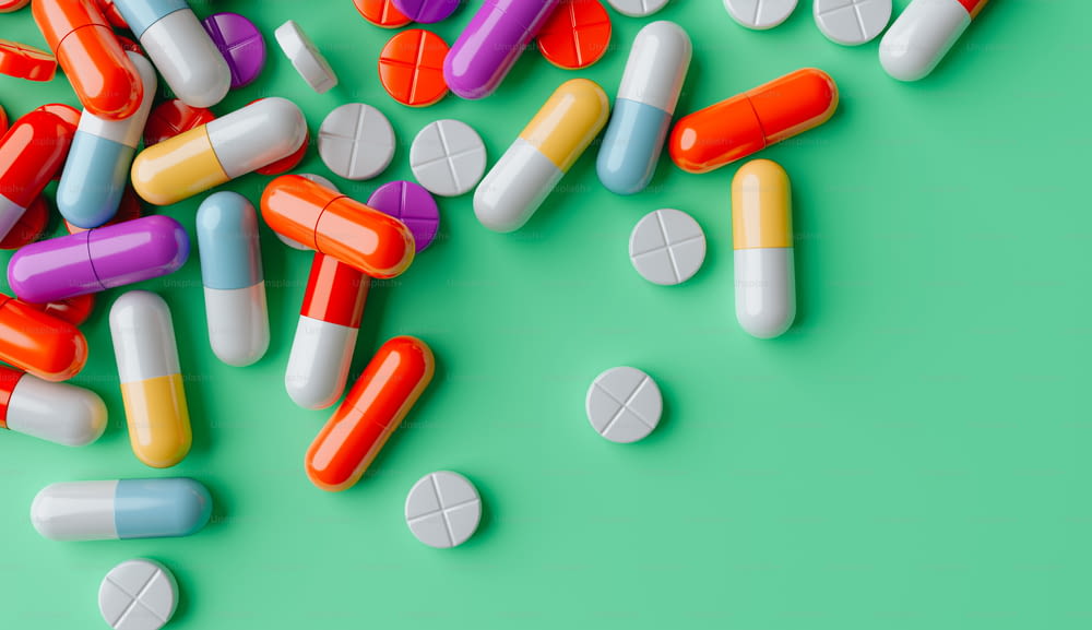 a pile of colorful pills on a green background