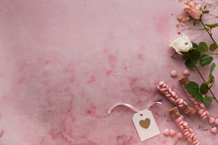 un tavolo di marmo rosa con perline rosa e una rosa bianca