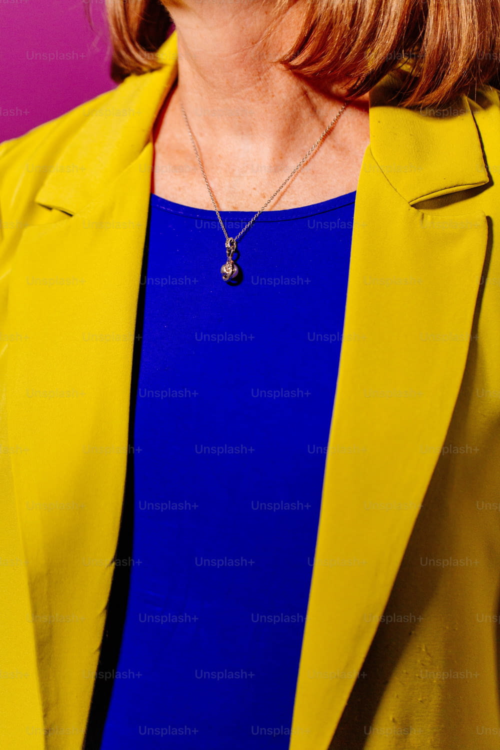 Una mujer con una chaqueta amarilla y una blusa azul