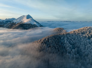 Una montaña cubierta de nieve y rodeada de nubes