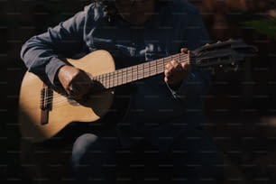 Un homme joue de la guitare à l’extérieur