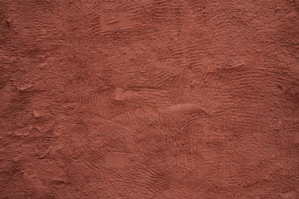 a close up of a red stucco wall