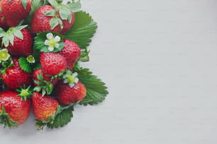 a group of strawberries with leaves and flowers