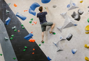 um homem está escalando em uma parede de escalada