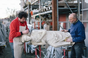 Due uomini che lavorano su una scultura in una fabbrica
