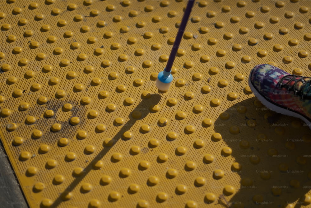 Una persona parada en una plataforma amarilla con un cepillo de dientes azul