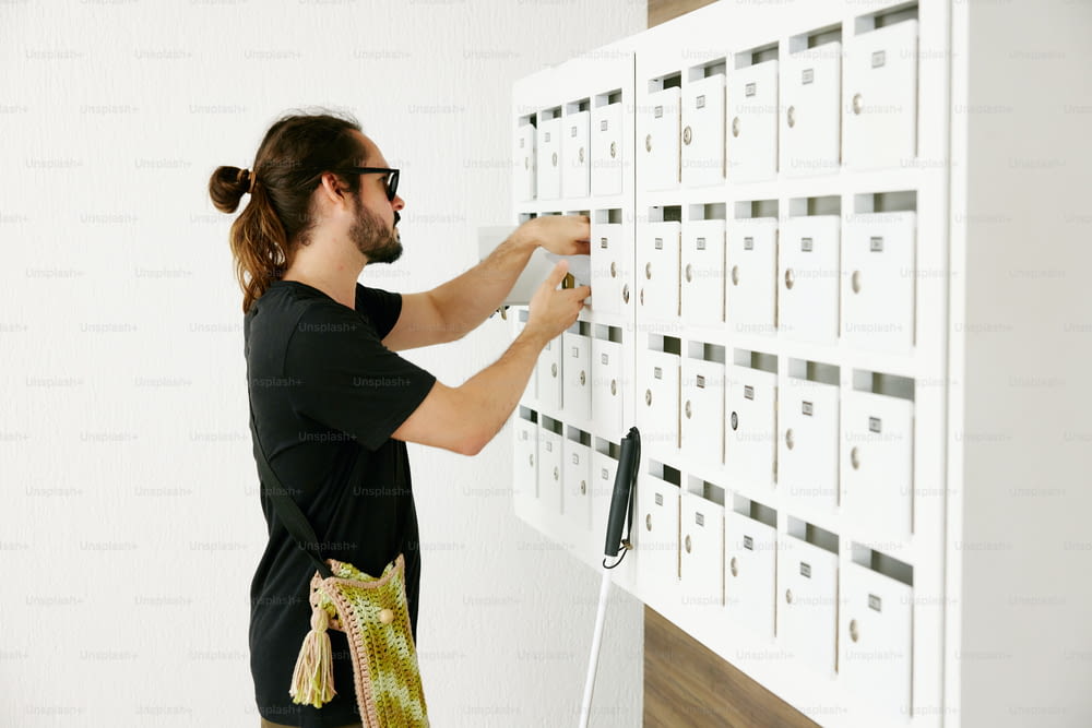 a man putting a lot of mail into a wall