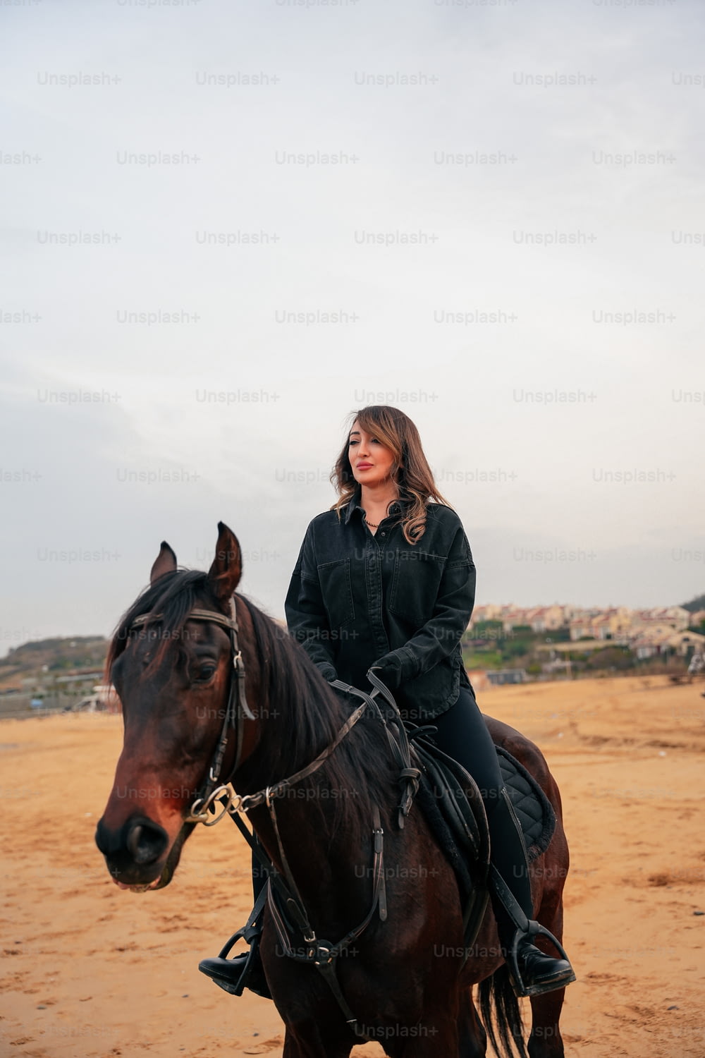 uma mulher que monta na parte de trás de um cavalo marrom