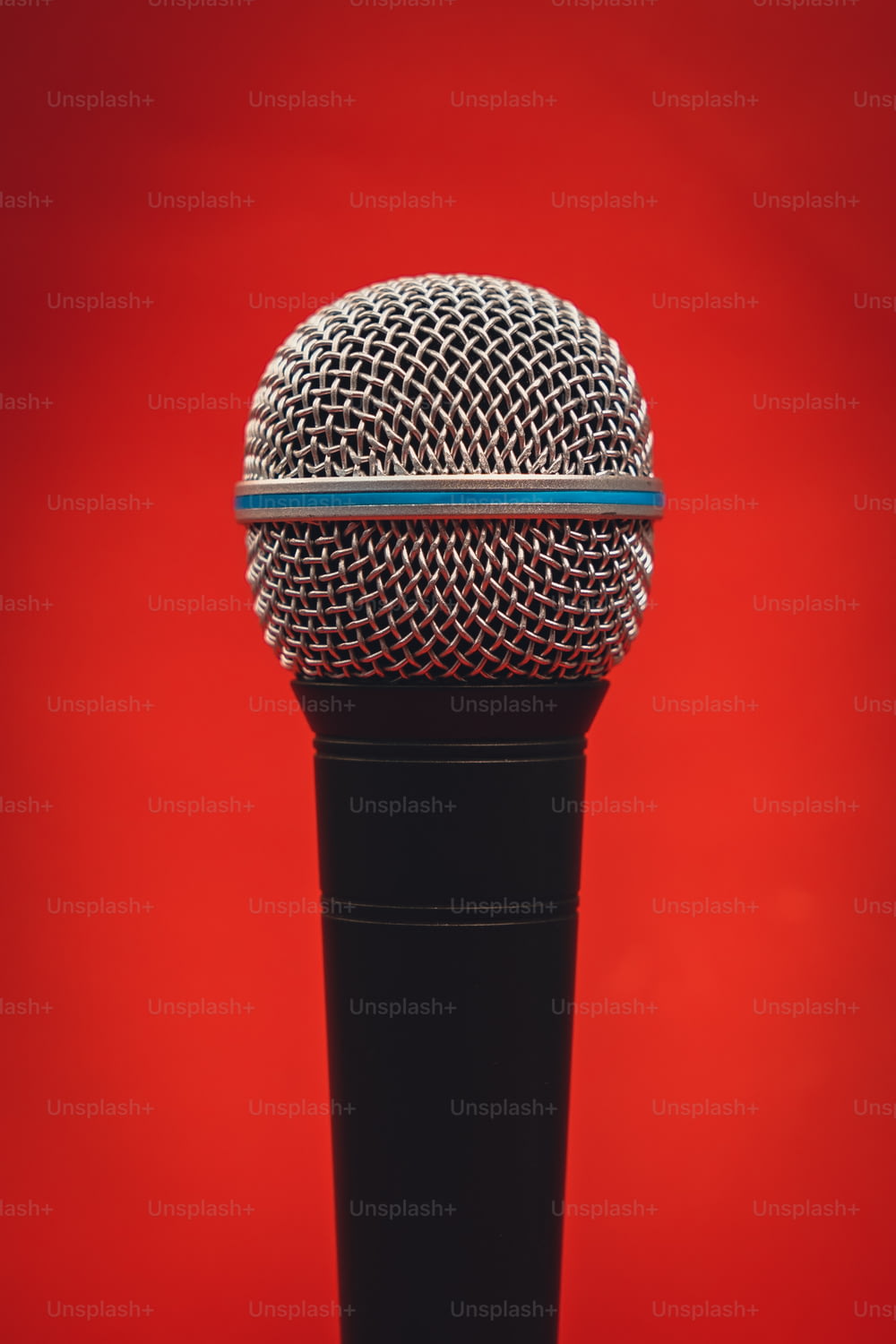 a microphone on a stand against a red background