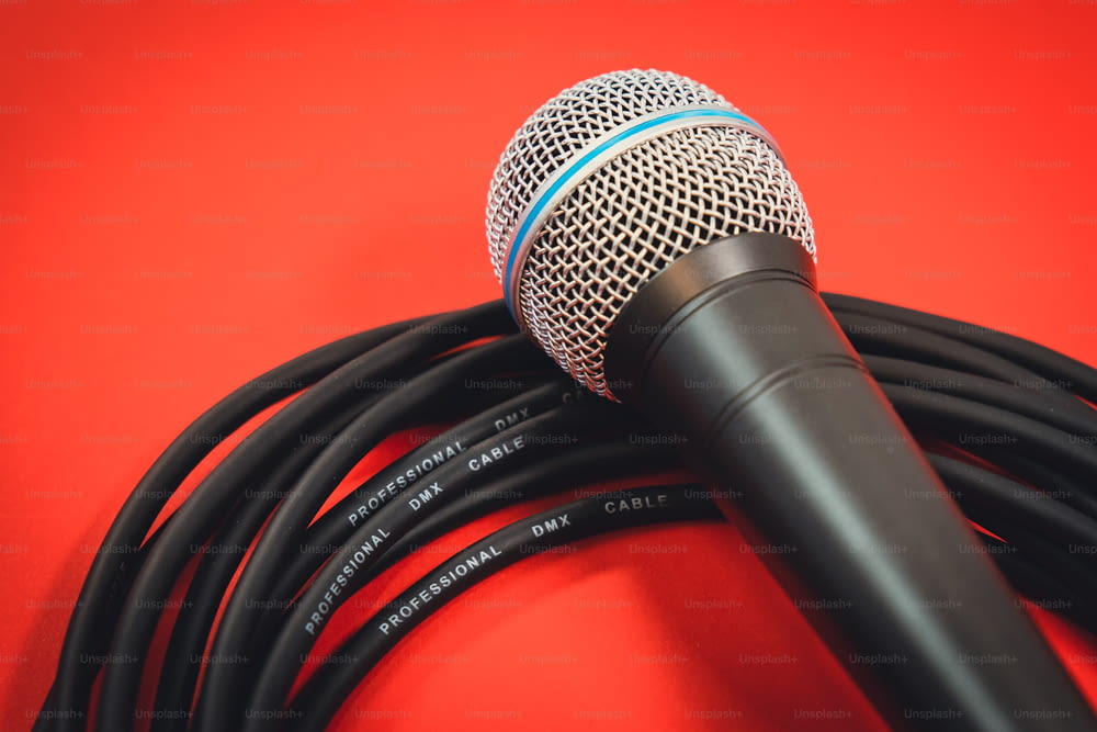 un microphone sur fond rouge avec un cordon noir