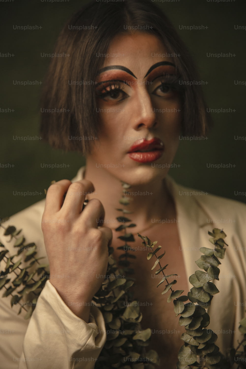 a woman with makeup on her face and leaves around her neck