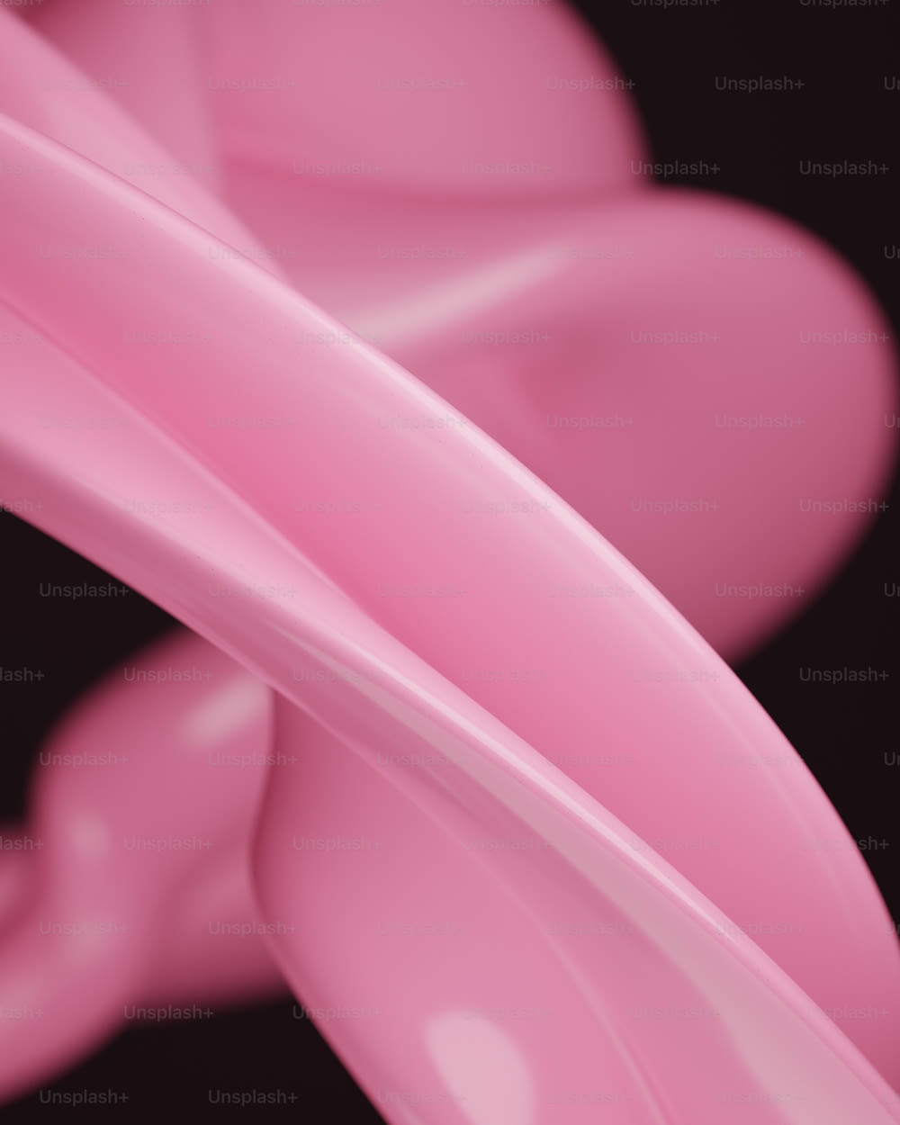 Un primer plano de un objeto rosa sobre un fondo negro