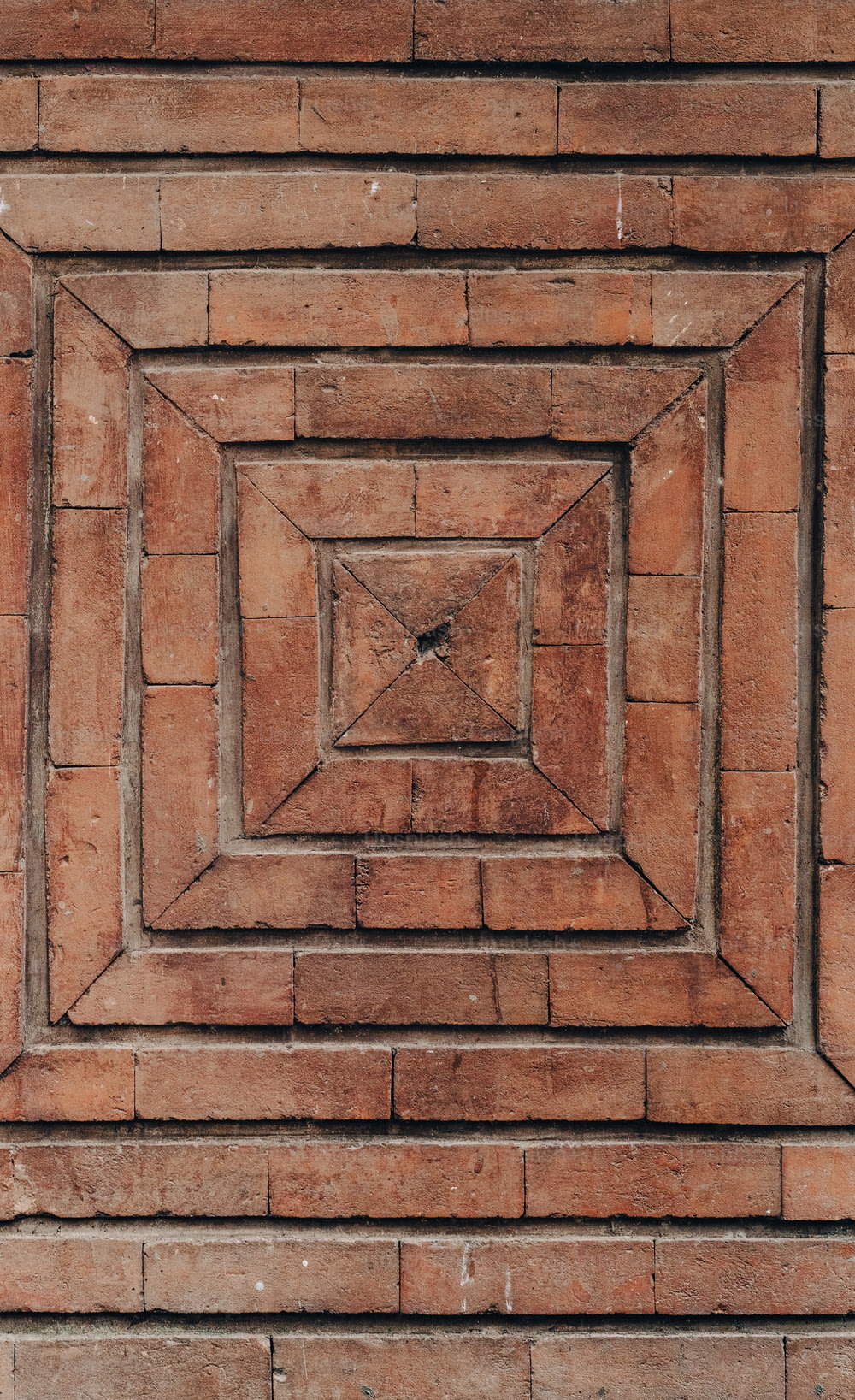 Un muro di mattoni con un disegno quadrato al centro