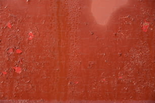 uma parede vermelha com gotas de água sobre ela