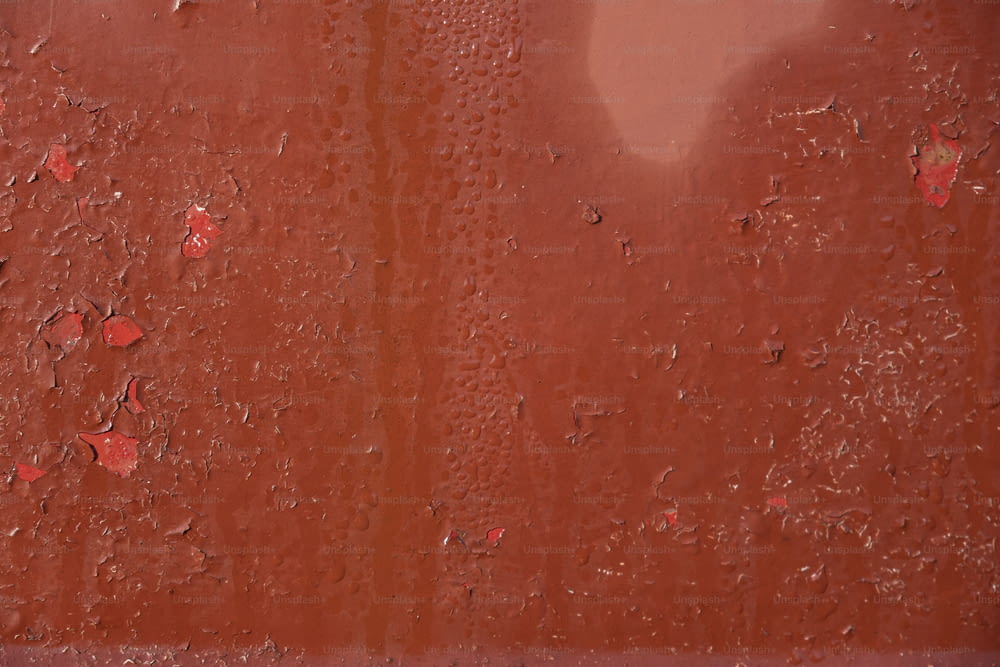 a red wall with drops of water on it