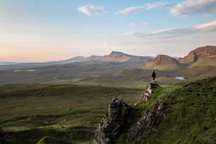 a person standing on top of a green hill
