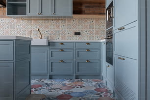uma cozinha com armários azuis e um piso frio