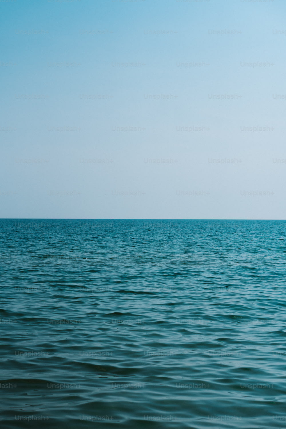 a large body of water sitting under a blue sky
