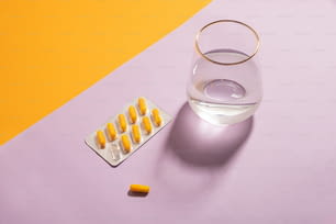una pillola e un bicchiere d'acqua su un tavolo