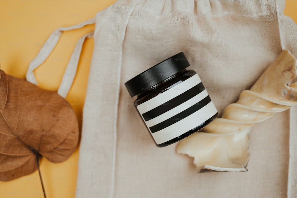 Un frasco blanco y negro encima de una bolsa