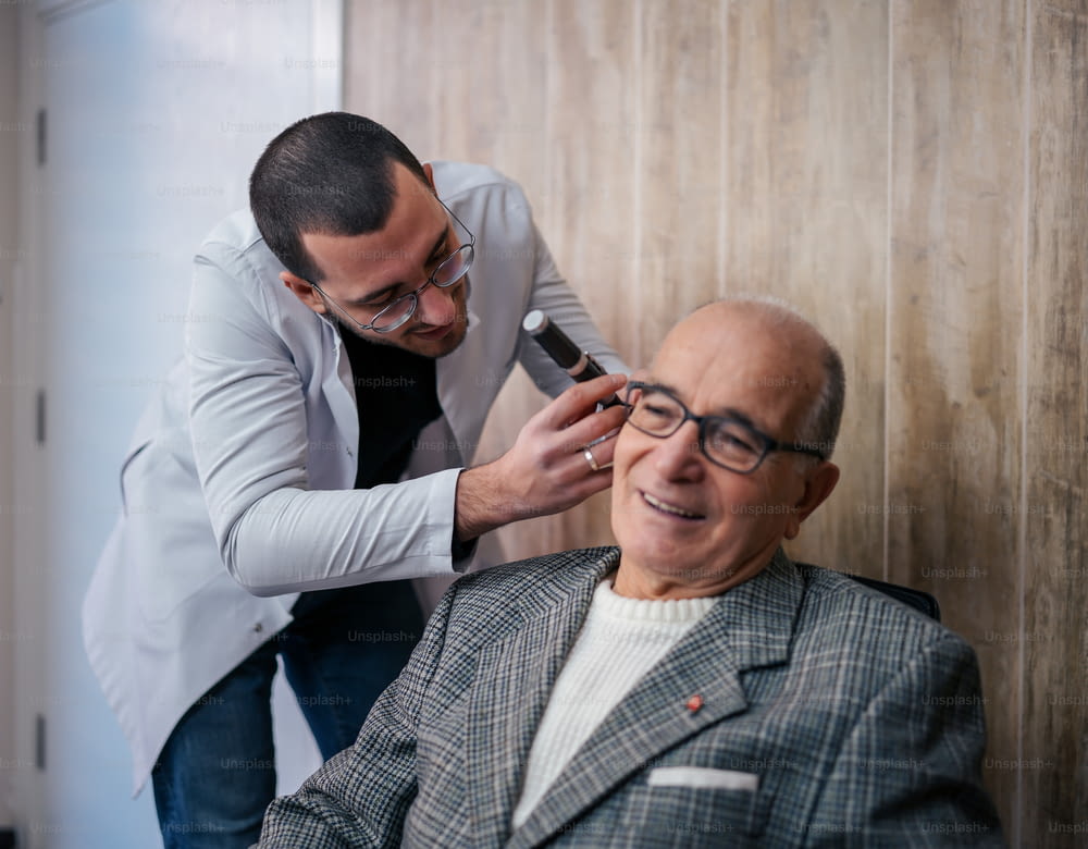 a man getting his hair cut by a man in a suit