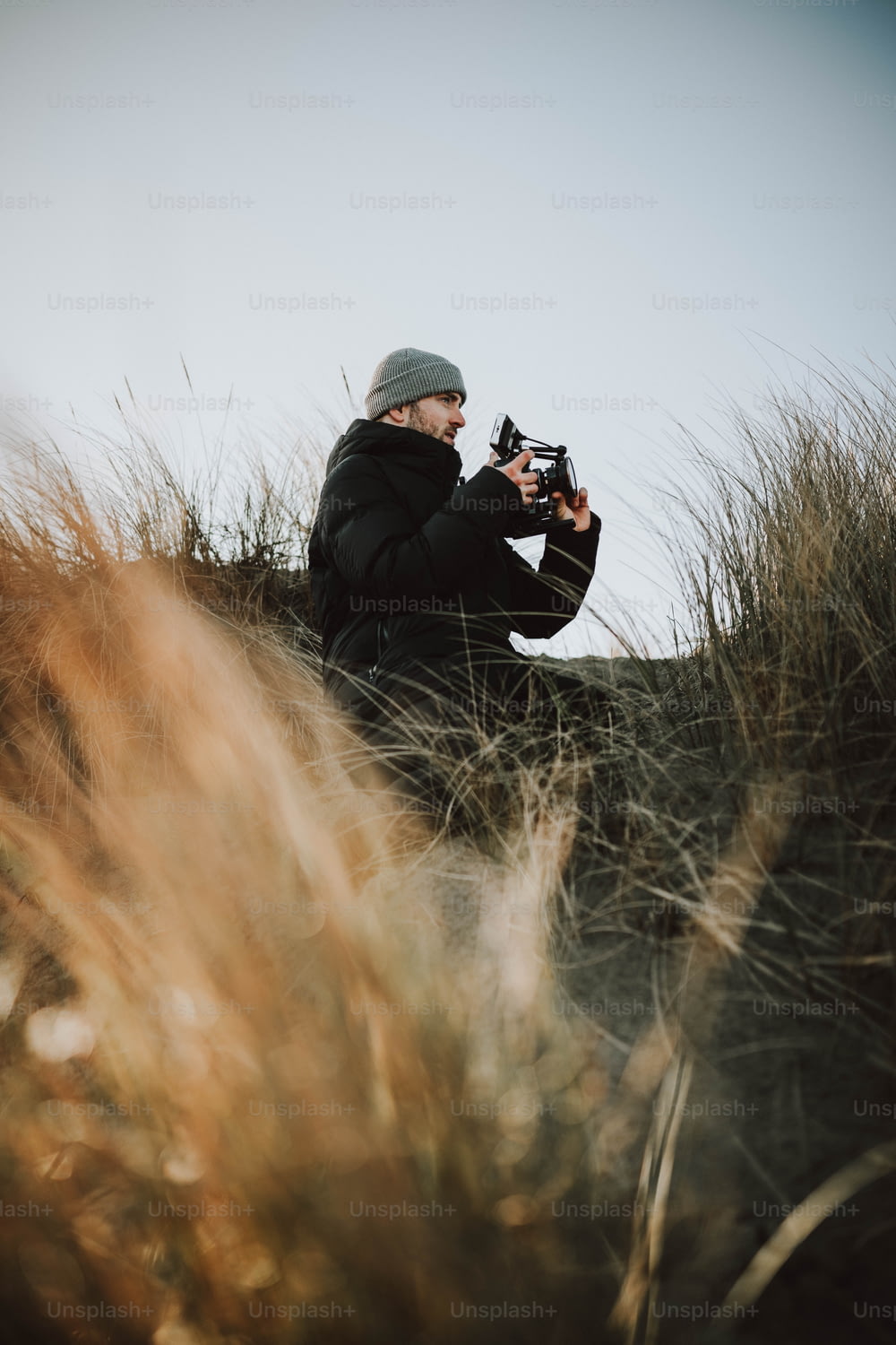 un uomo seduto in un campo che scatta una foto con una macchina fotografica