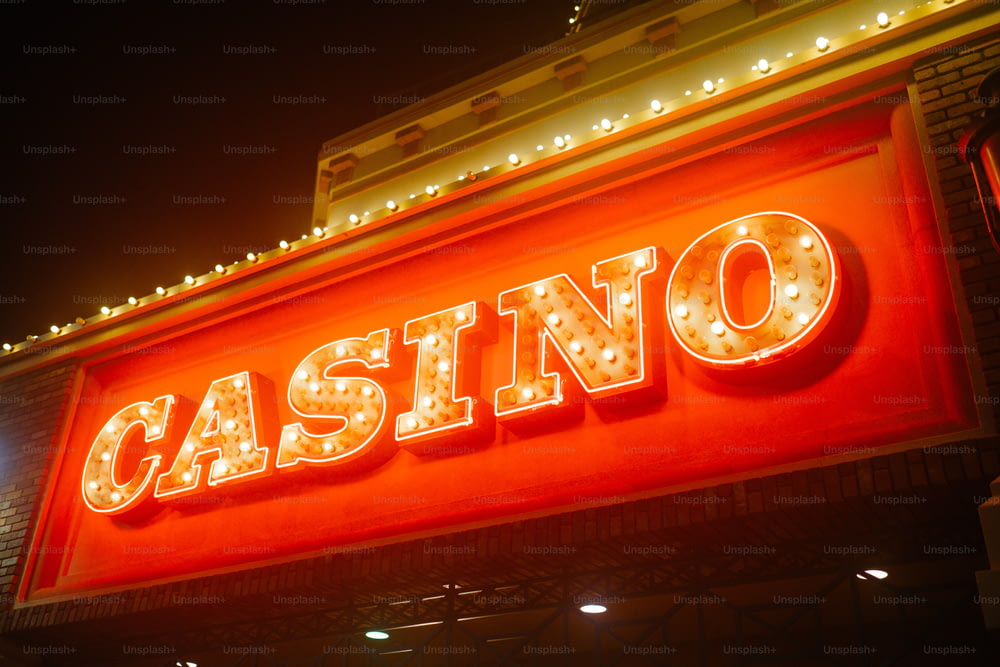 uma placa de casino iluminada à noite com luzes