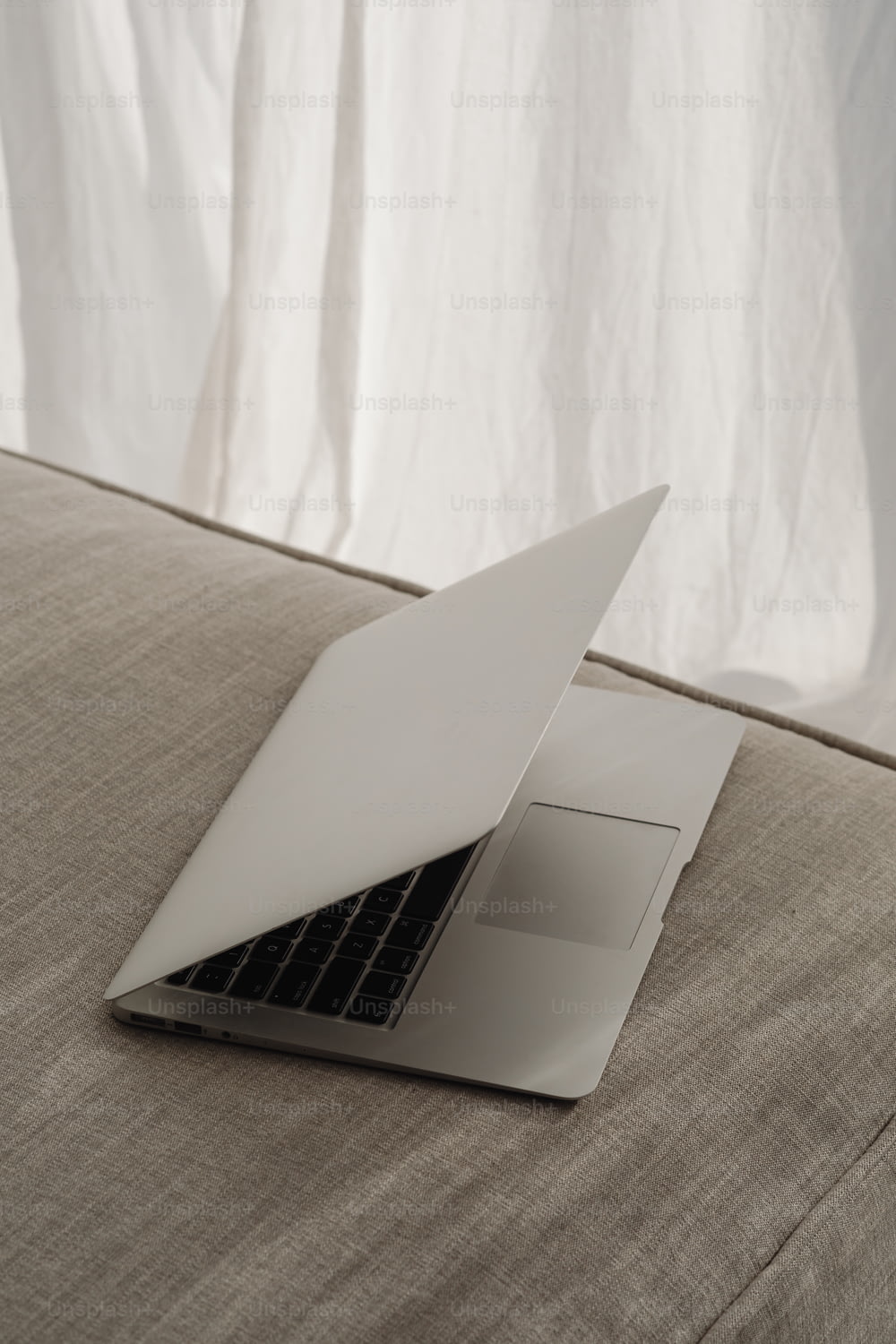 an open laptop computer sitting on top of a bed