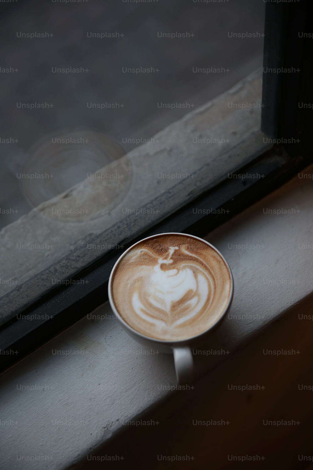 창틀에 앉아있는 커피 한 잔