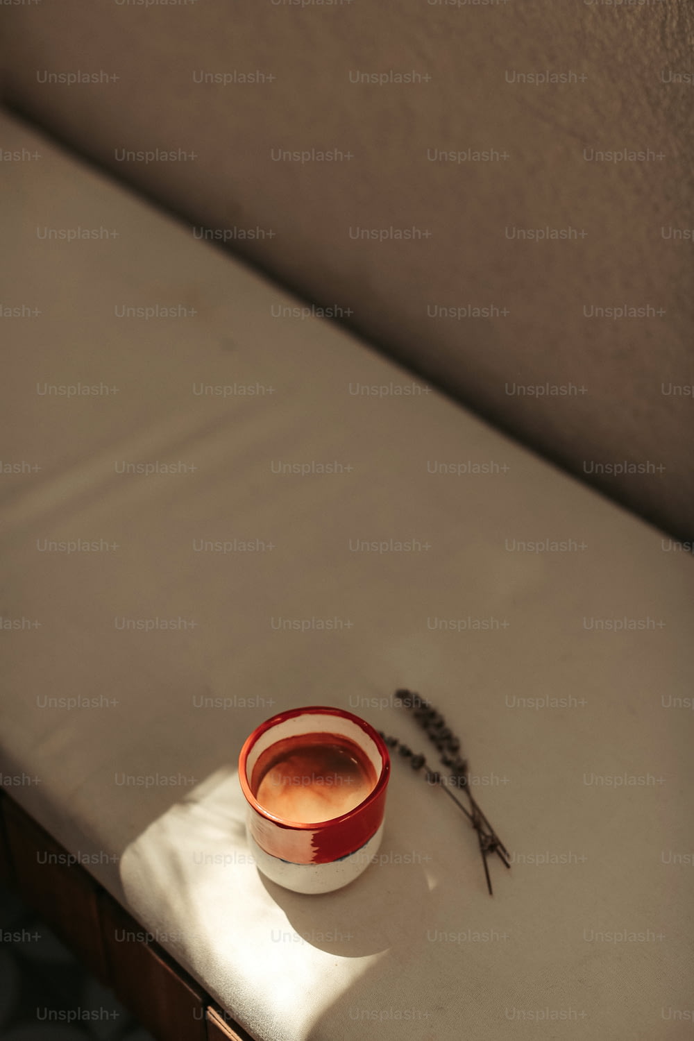 a small cup of tea sits on a bed