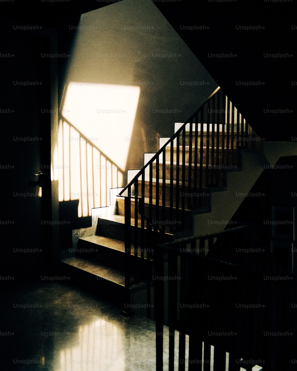 une cage d’escalier avec une lumière passant par la fenêtre