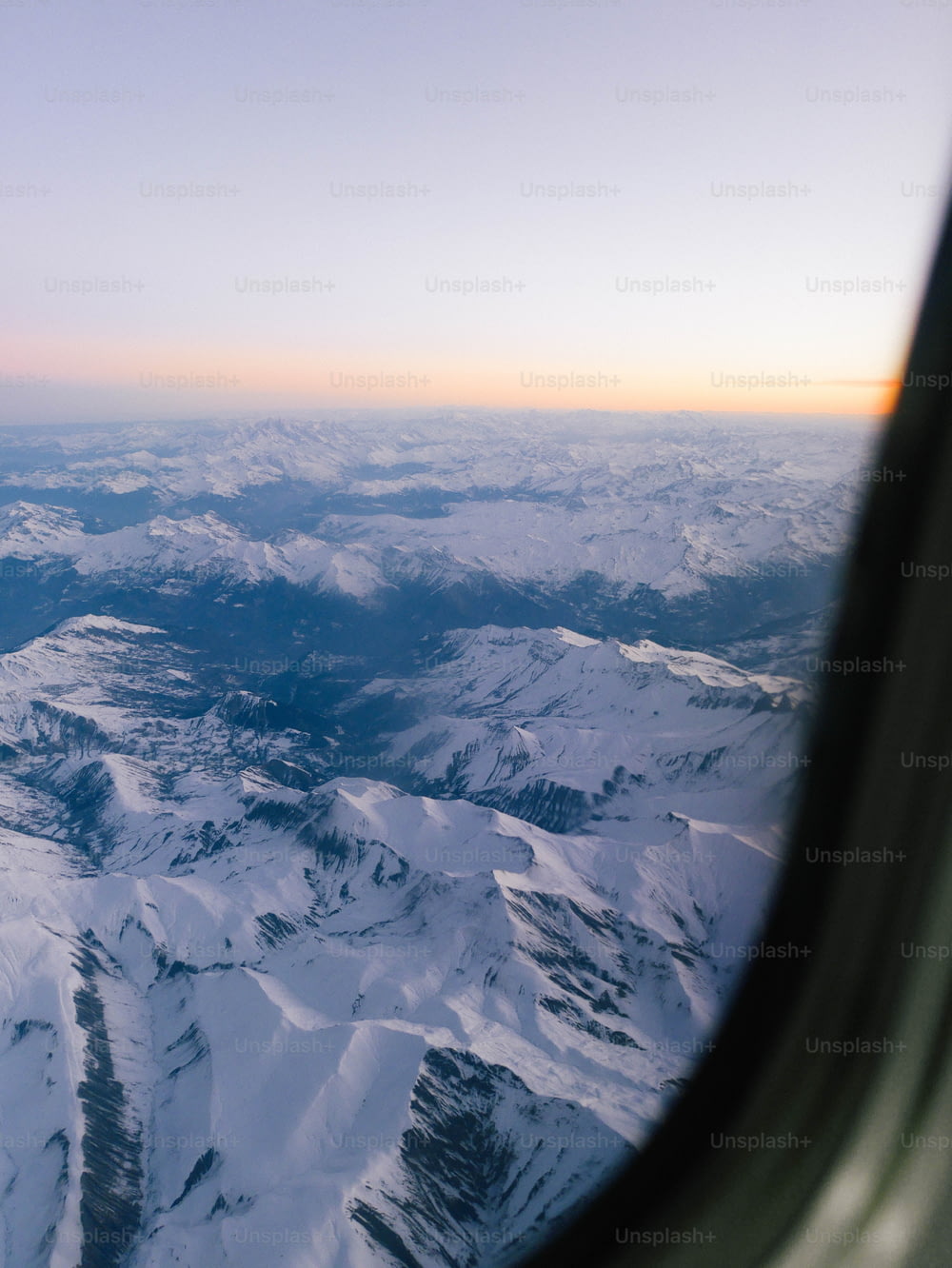 Una vista di una catena montuosa dal finestrino di un aeroplano
