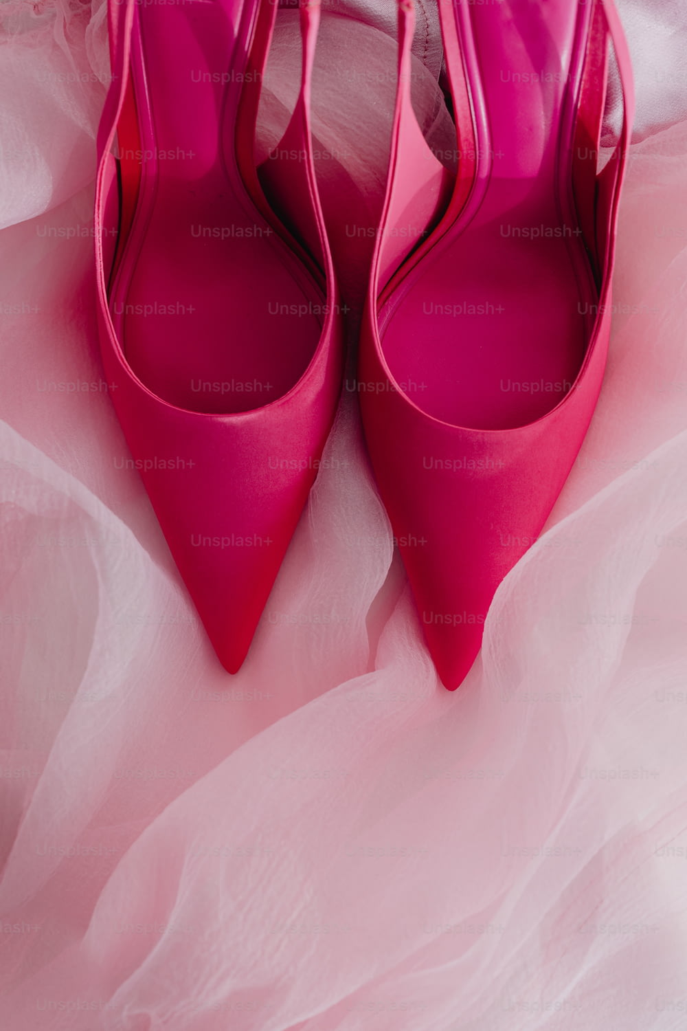 a pair of pink shoes sitting on top of a bed