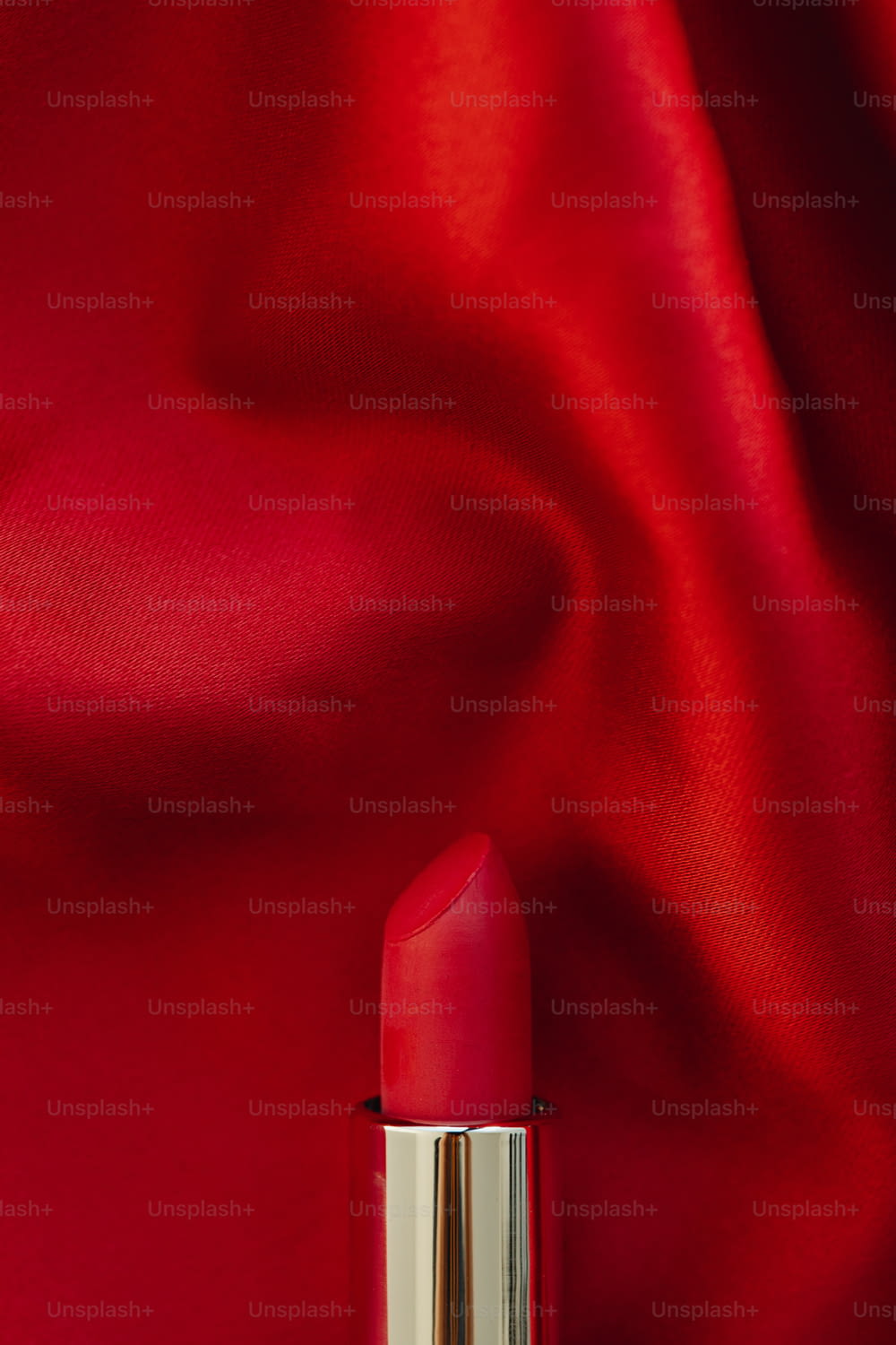 eine Nahaufnahme eines Lippenstifts auf rotem Hintergrund