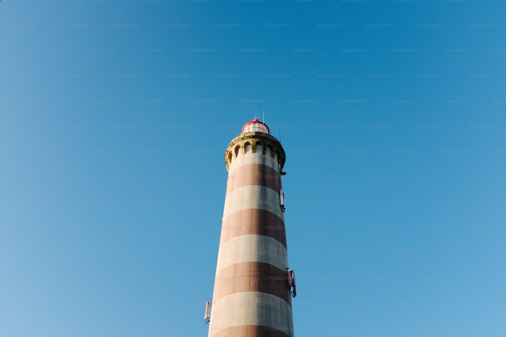 a tall light house with a blue sky in the background