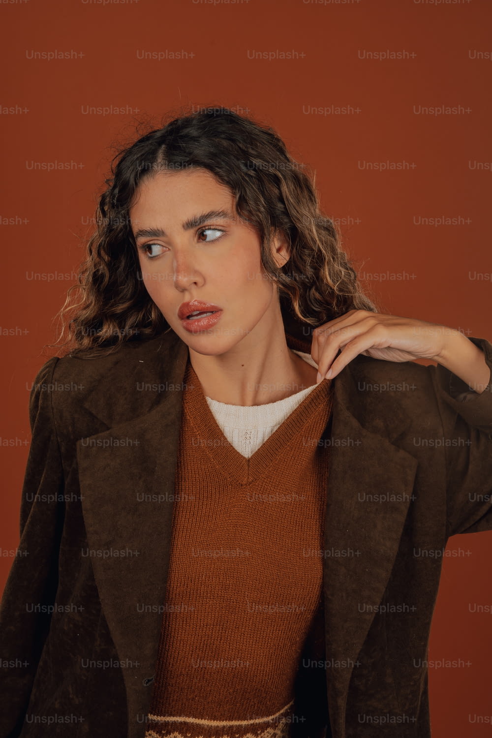 Una donna in un maglione marrone e una giacca marrone