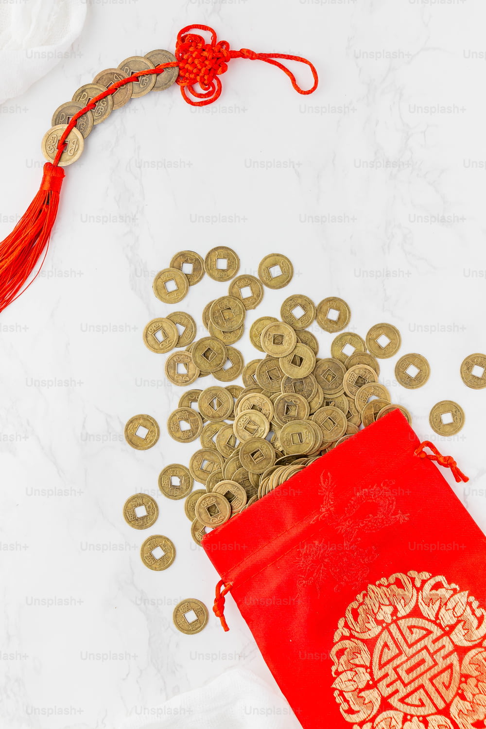 a red bag filled with gold coins next to a red bag filled with gold coins