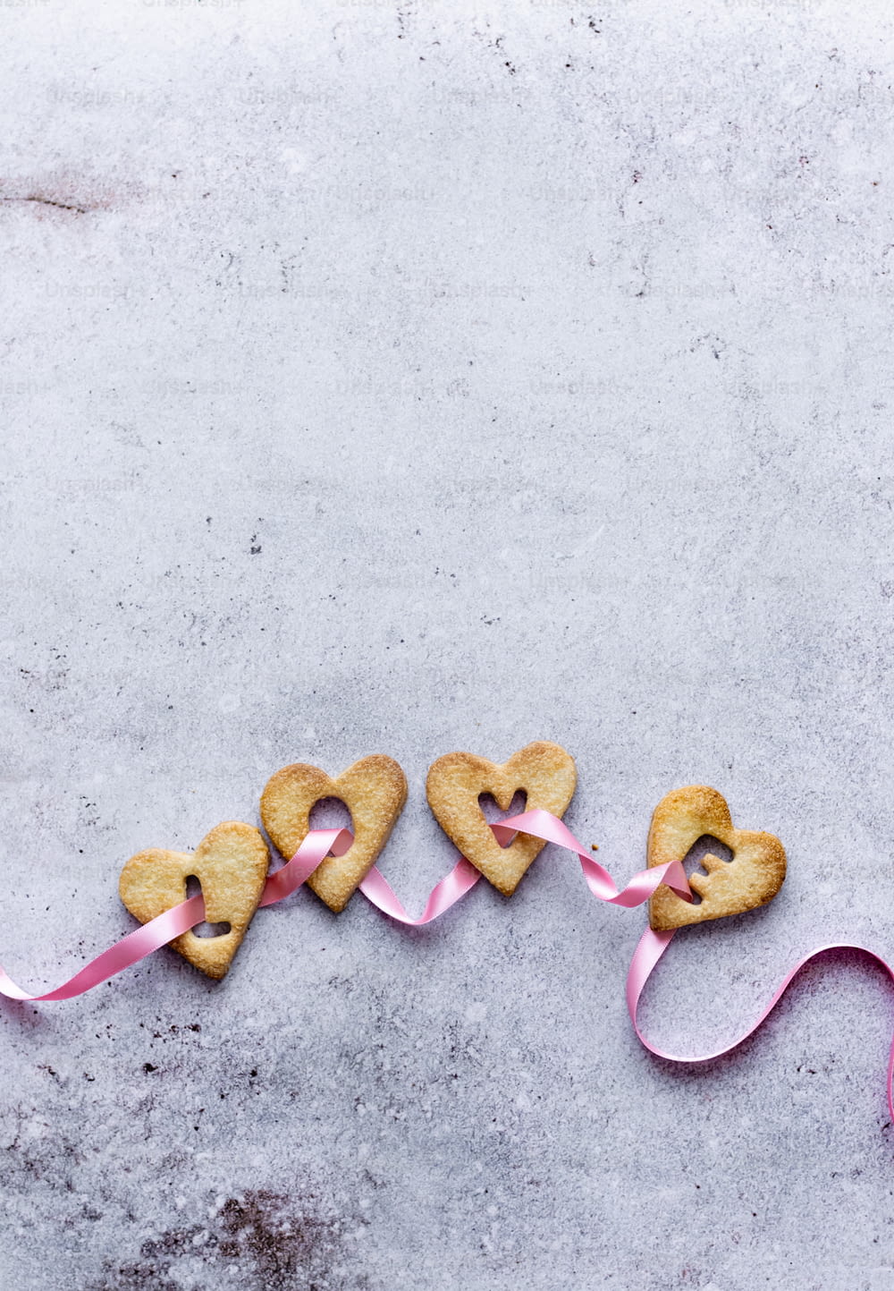 Un par de galletas en forma de corazón sentadas encima de una mesa