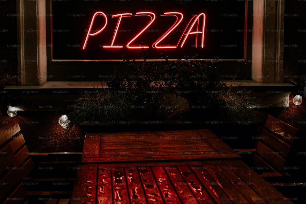 a red neon sign that reads pizza on it