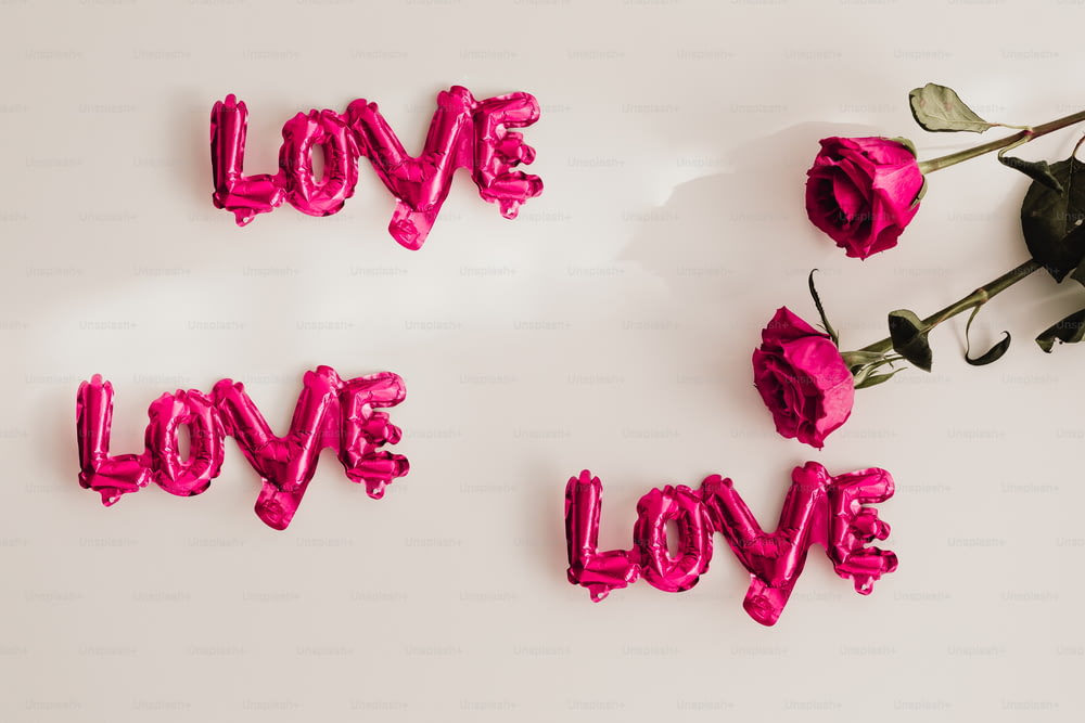a palavra amor soletrada com balões cor-de-rosa e flores