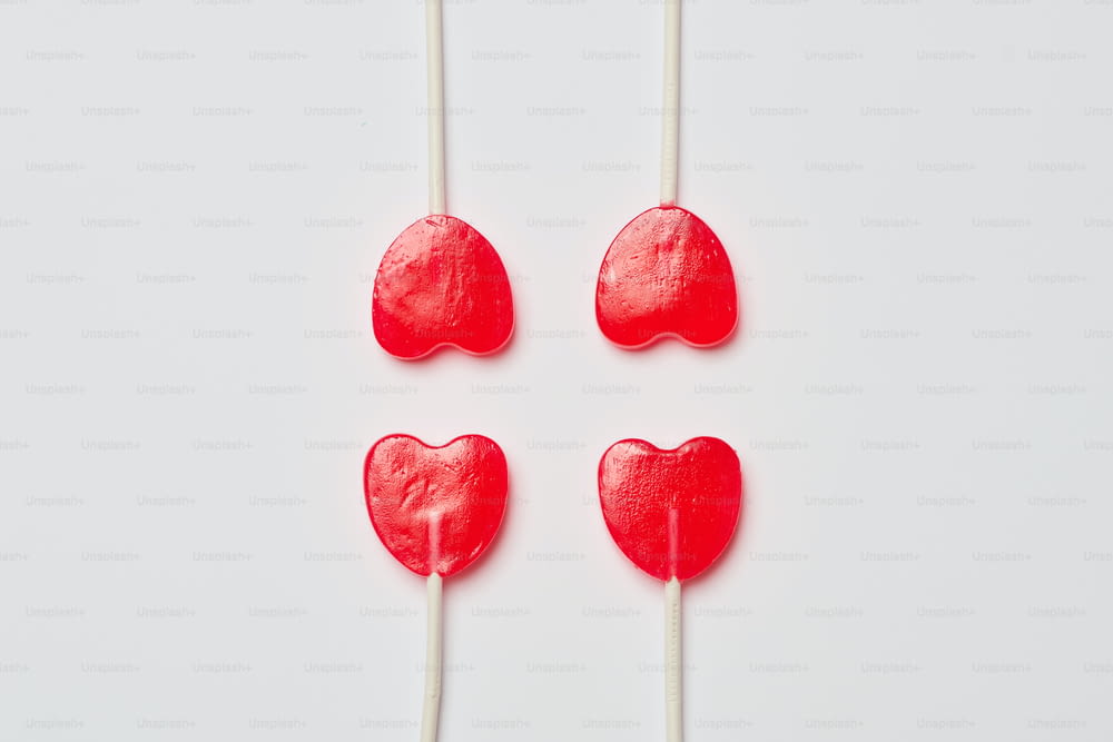 four heart shaped lollipops on a white background