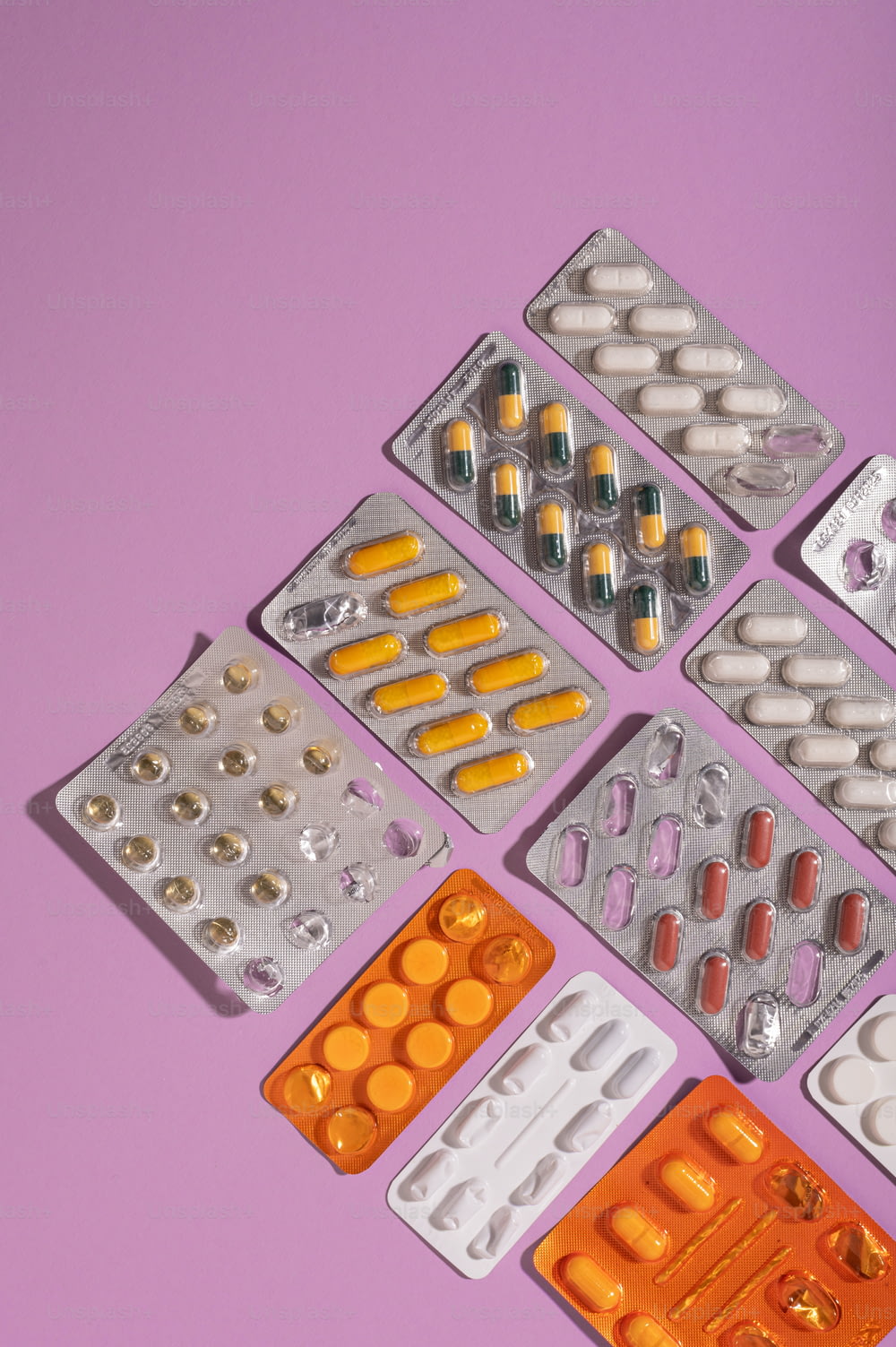 Eine Gruppe von Pillen und Tabletten auf violettem Hintergrund